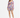 A model poses in a colorful floral dress with long sleeves and a cinched waist, paired with strappy heels.
