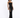 A model poses in a black, glittery dress featuring cut-out details along the sides, paired with black heels.