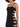 A close-up of a fitted black dress featuring cut-out details and thin straps, showcasing a sparkly texture.