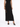 A fitted black dress with cut-out details and a shimmering fabric, paired with open-toe black heels.