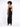 A model showcases a black, glittery dress with cut-out details along the sides, paired with high heels.