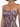 Close-up of a model wearing a fitted, one-shoulder dress with a floral abstract pattern in muted tones.