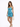 A model poses in a shimmering turquoise dress with ruching, paired with a pearl handbag and strappy heels.