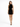 A model poses in a sleeveless black dress with side cutouts and crisscross detailing, paired with strappy heels.