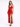 A model poses in a sleek red satin dress with a deep neckline and a thigh-high slit, paired with black heels.