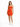 A woman wearing a fitted orange dress with a cutout detail, paired with white sneakers, standing against a plain back...