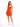 A model poses in a fitted orange dress with spaghetti straps and a cutout detail, paired with white sneakers.