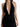 A woman models a sleek black halter dress featuring a deep V-neckline and side ruching.