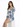 A model poses in a fitted dress with a floral blue and white pattern, featuring puffed sleeves and a square neckline.