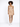 A model poses in a fitted, ribbed beige dress paired with white sneakers against a plain background.