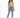A woman stands confidently in a light green crop top and high-waisted blue jeans, paired with white sneakers.