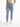 A person wearing light blue high-waisted jeans paired with a fitted green crop top and white sneakers.