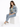 A woman sits on a white cube, wearing a denim jacket, light green top, and light blue jeans with white sneakers.