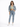 A woman stands confidently in a cropped denim jacket, fitted green top, and light blue jeans, paired with white sneak...