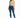 A woman stands confidently in a light green crop top and distressed blue skinny jeans, paired with white sneakers.