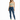 A woman stands confidently in a light green crop top and distressed blue skinny jeans, paired with white sneakers.