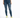 A woman wearing a cropped green top and distressed blue skinny jeans, paired with white sneakers featuring neon accents.