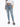 A person wearing light blue high-waisted jeans and gray fuzzy slides, standing against a plain white background.