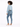 A model with curly hair wears a light blue cropped top, fitted jeans, and white sandals, posing from the back.