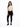 A model poses in a fitted beige long-sleeve top with cut-out details, paired with black skinny jeans and sneakers.