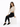 A woman sits on a white cube, wearing a fitted ribbed long-sleeve top and black skinny jeans with casual sneakers.