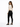 A woman with long hair poses in a fitted beige top and black skinny jeans, showcasing a stylish back cutout.