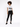 A model poses in a white graphic t-shirt and black skinny jeans, paired with black sneakers.