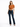 A woman stands confidently in a tied, rust-colored top and dark flared jeans, paired with black heels.