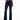 A person wearing a tied orange top and dark flared jeans, standing in black heeled sandals against a white background.