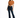 A woman poses in a cropped, rust-colored top tied at the waist, paired with dark flared jeans and heels.