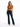 A woman stands confidently in a cropped, rust-colored top and dark flared jeans, paired with black heels.