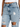 Light blue distressed denim jeans featuring ripped details and a high-waisted fit, styled with a white top.