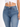 Close-up of a person wearing high-waisted blue jeans paired with a white cropped top, showcasing a casual style.