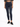 A person wearing dark blue skinny jeans paired with a cropped graphic t-shirt and black sneakers.