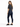 A woman stands with her back to the camera, wearing a cropped gray t-shirt and dark skinny jeans.