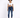 A model wearing a white cropped top and blue skinny jeans, paired with white sneakers, standing against a light backg...