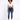 A model wearing a white cropped top and blue skinny jeans, paired with white sneakers, standing against a light backg...
