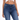 A close-up of a person wearing a white cropped top and dark blue fitted jeans, showcasing a casual style.