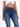 A close-up of a person wearing a white cropped top and dark blue fitted jeans, showcasing a casual style.