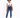 A model poses in a cropped white top and fitted blue jeans, paired with white sneakers against a light background.