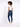 A model with curly hair wears a white fitted top and blue skinny jeans, paired with white sneakers.