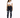 A woman stands confidently in a cropped white top and dark skinny jeans with distressed details, paired with white sn...