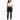 A woman stands confidently in a cropped white top and dark skinny jeans with distressed details, paired with white sn...