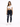 A woman stands confidently in a cropped white top and dark skinny jeans with distressed details, paired with white sn...