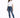 A woman stands confidently in a casual white t-shirt and distressed blue jeans, paired with white sneakers.