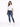 A woman stands confidently in a casual white t-shirt and distressed blue jeans, paired with white sneakers.