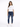 A woman stands confidently in a white t-shirt and distressed blue jeans, paired with white sneakers.