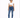 A model poses in a cropped white top with a drawstring and blue skinny jeans, paired with white sneakers.