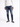 A person wearing a white hoodie, distressed blue jeans, and black sneakers stands against a plain background.