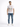A man stands confidently in a white graphic t-shirt and distressed blue jeans, paired with white sneakers.